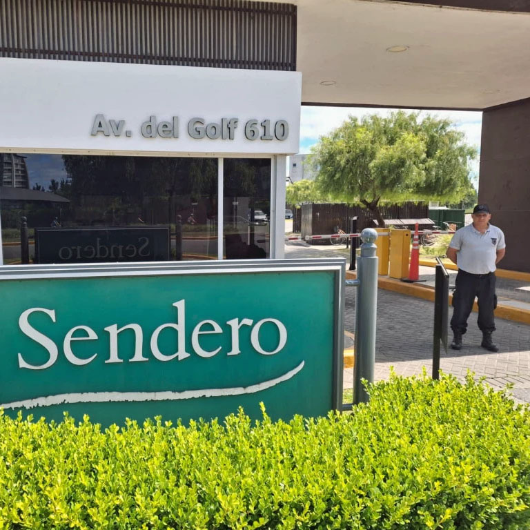 barber using styling spray on young man with black hair, short on sides and long in a quiff on top